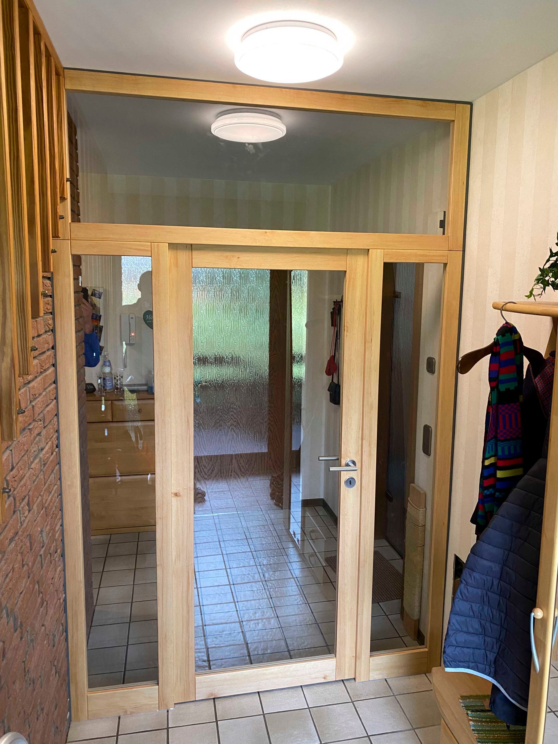 Ein Flur mit einer Holztür und einer Ziegelwand