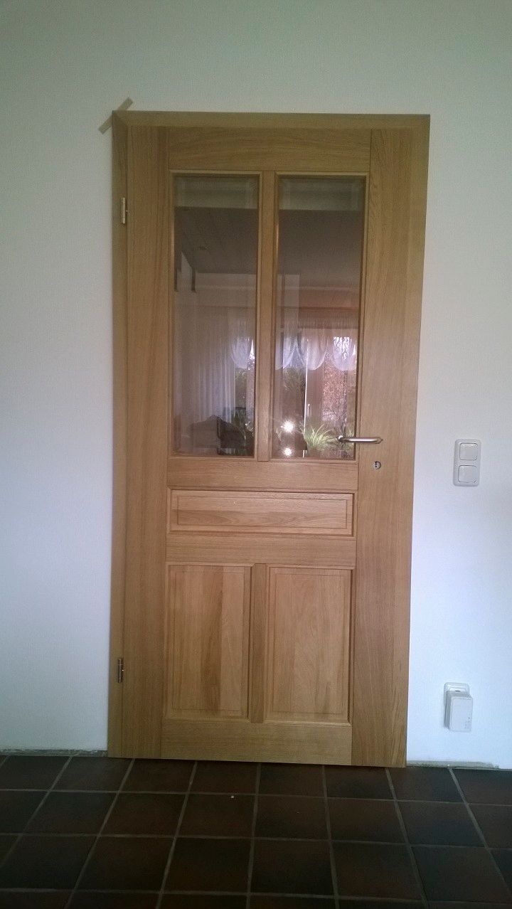 Eine Holztür mit einem Glasfenster in einem Raum.