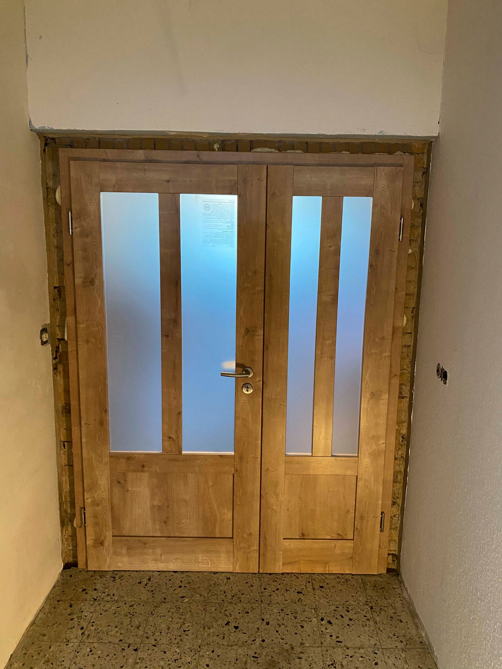 Eine Holztür mit Milchglas in einem Flur