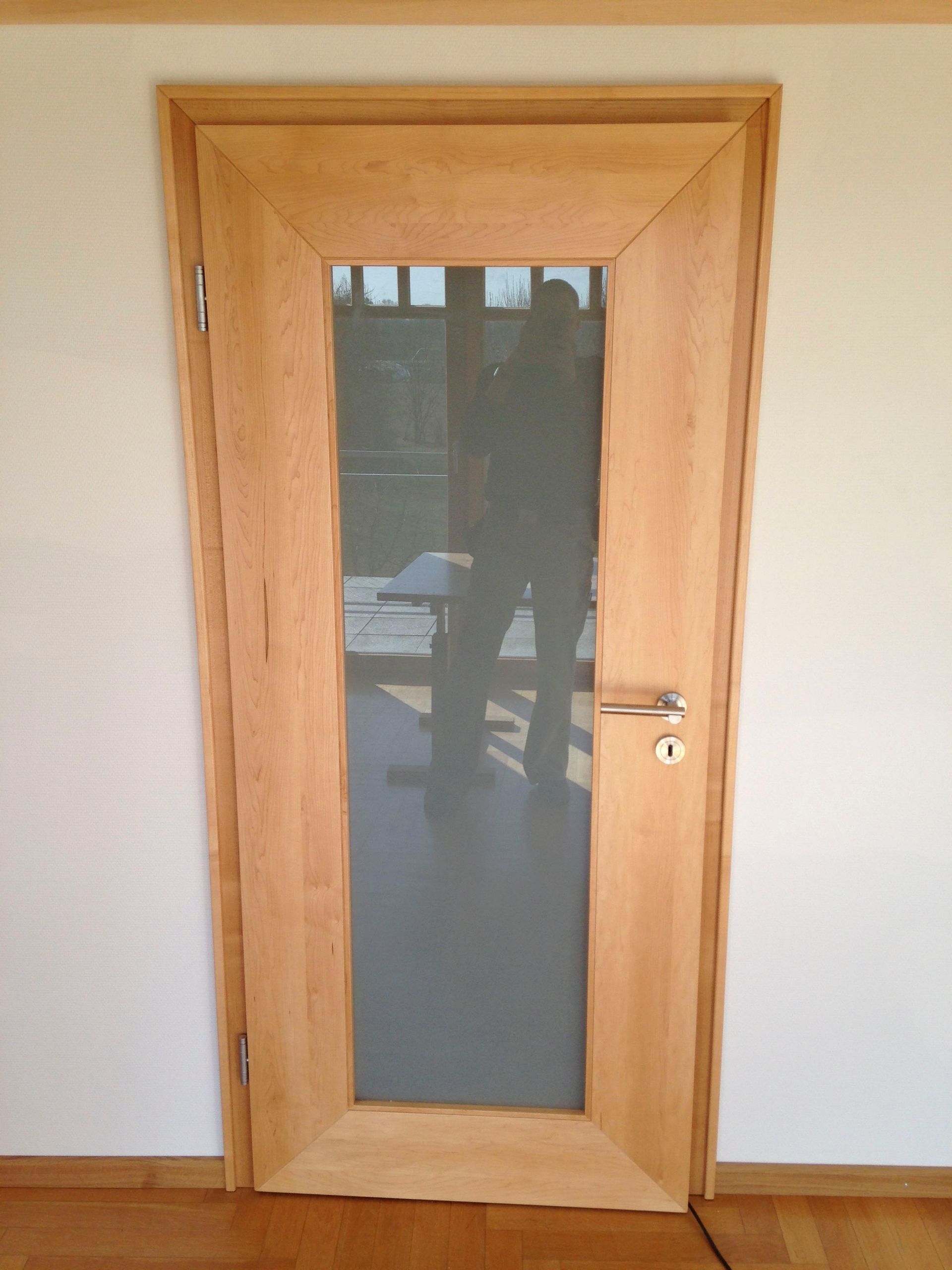 Eine Holztür mit einem Glasfenster in einem Raum.