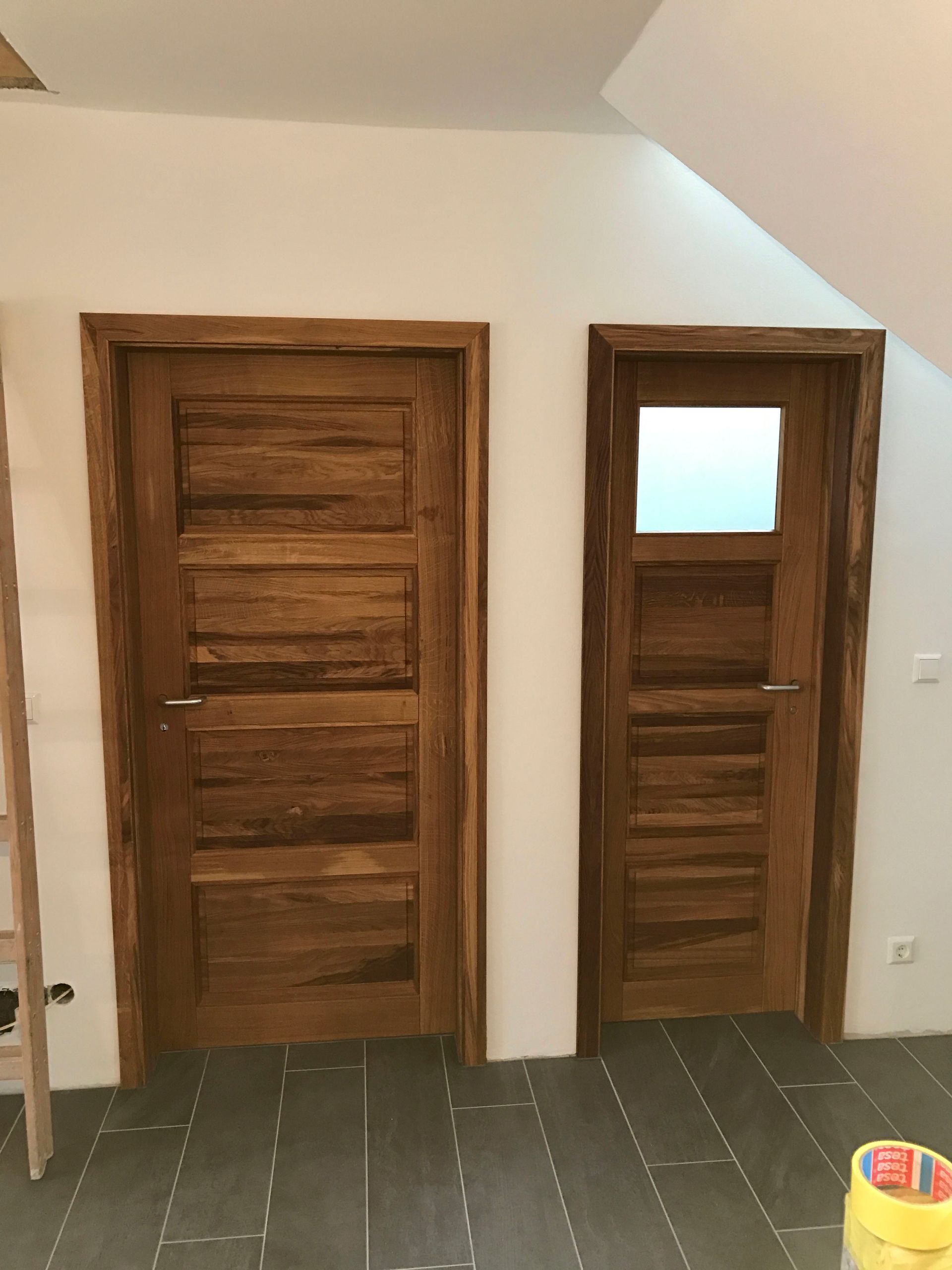 Zwei Holztüren in einem Raum mit einer Leiter im Hintergrund