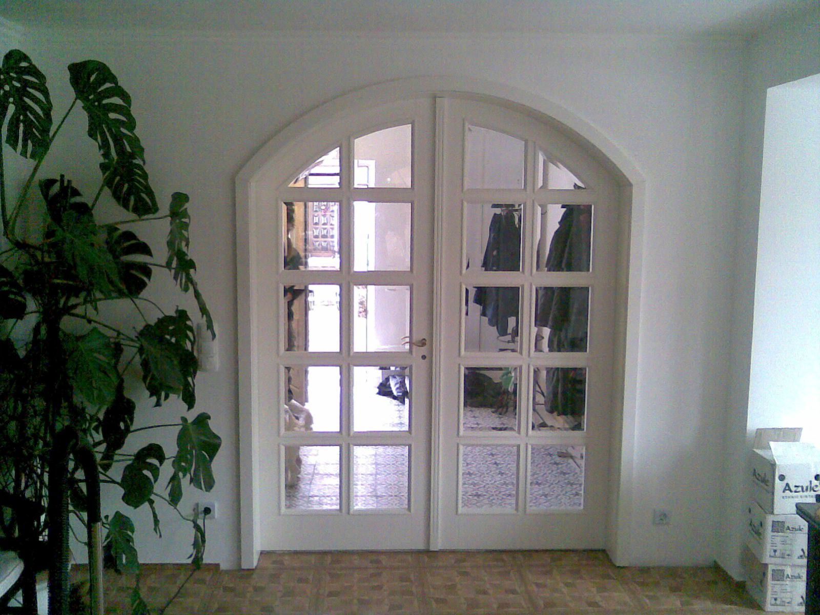 Ein Zimmer mit einer Pflanze und einer weißen Tür