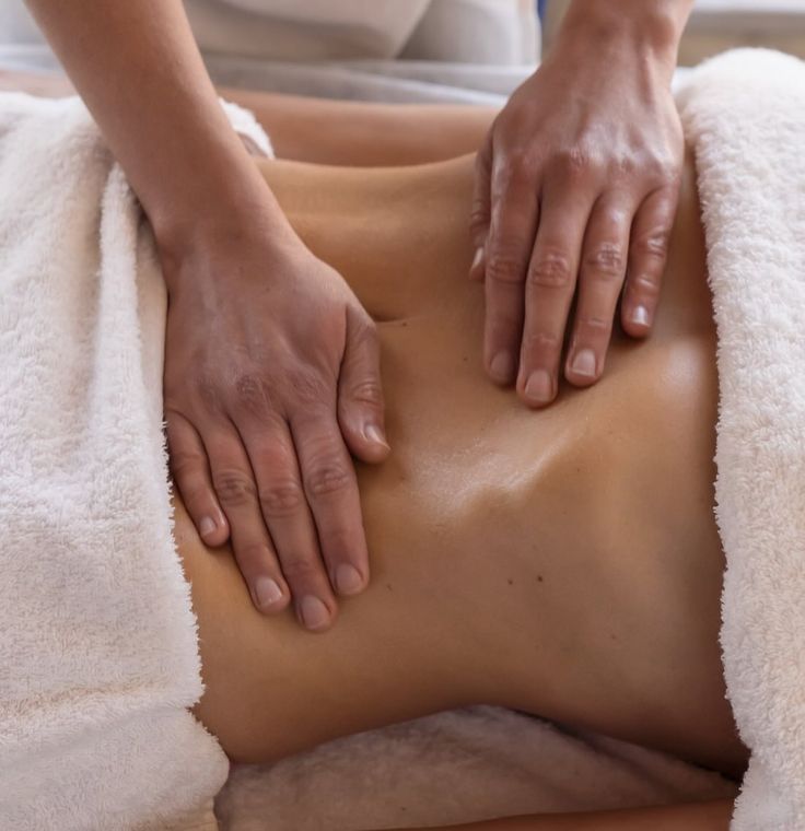 Une femme se fait masser les mains sur le ventre