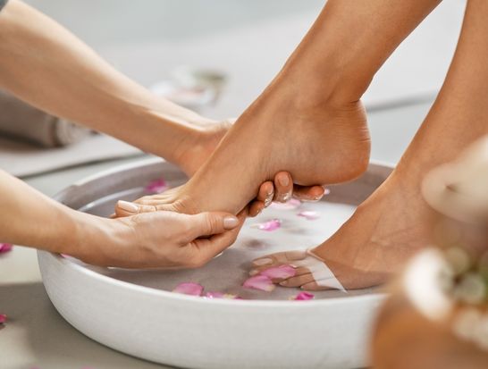 Une femme se fait laver les pieds dans un bol d'eau.