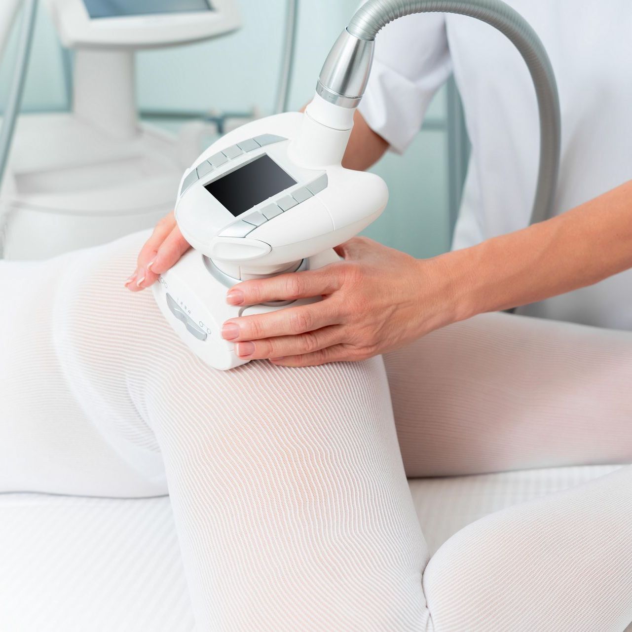 Une femme se fait masser la jambe avec une machine.