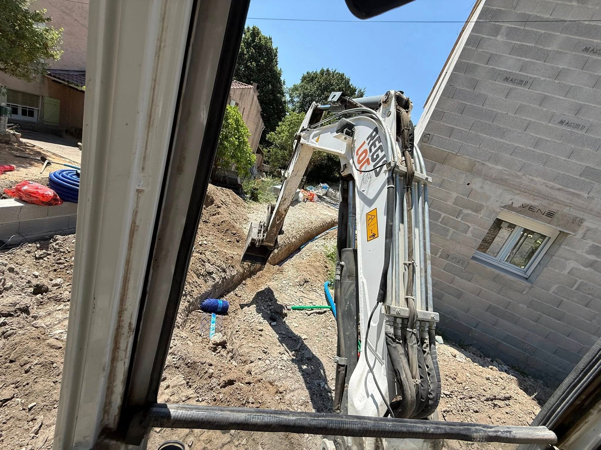 Un engin de chantier blanc creusant un trou.