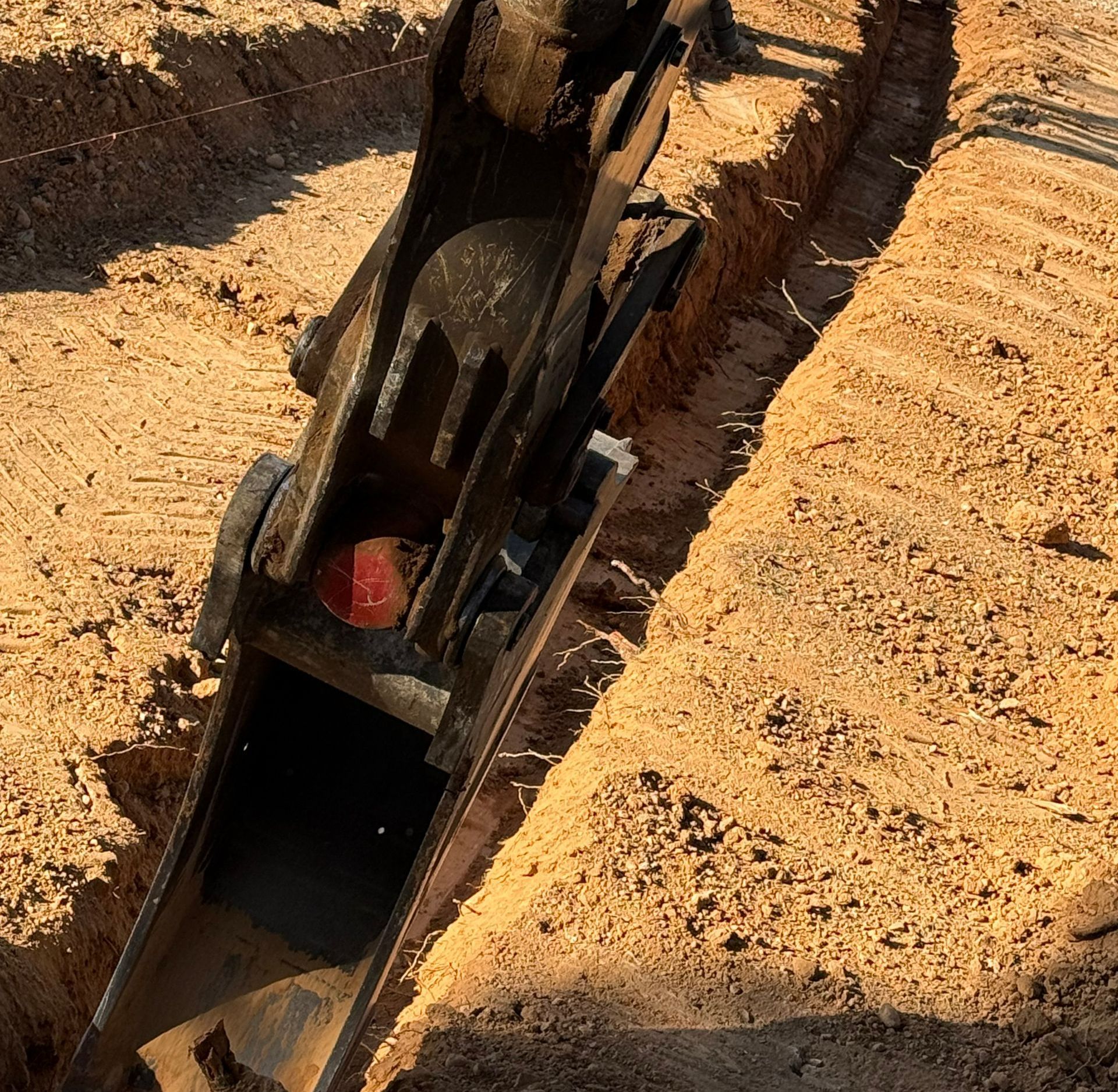 Un engin de chantier qui creuse dans la terre.