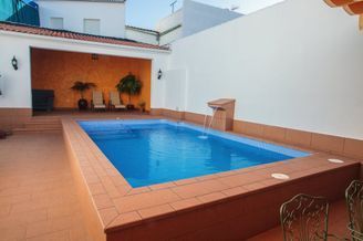 Hay una gran piscina en el patio trasero de una casa.