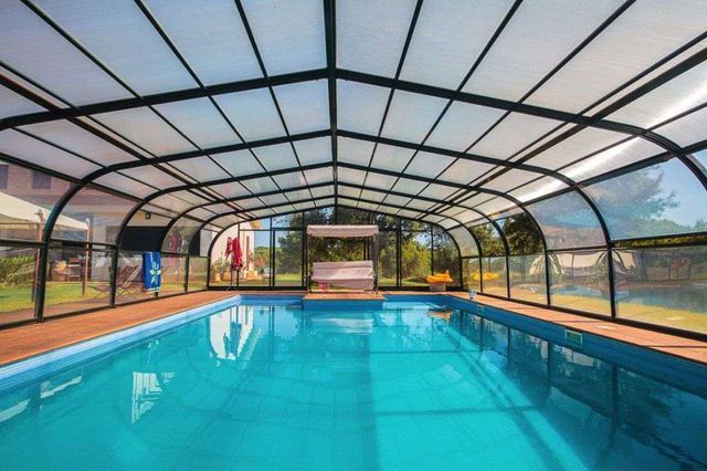 Una gran piscina cubierta con techo transparente