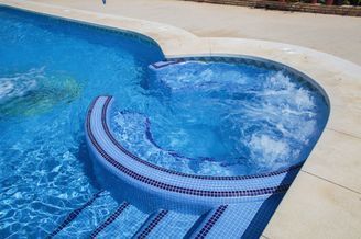 Hay un jacuzzi en el medio de la piscina.