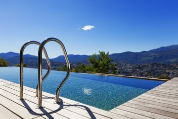 Hay una piscina con vista a las montañas al fondo.
