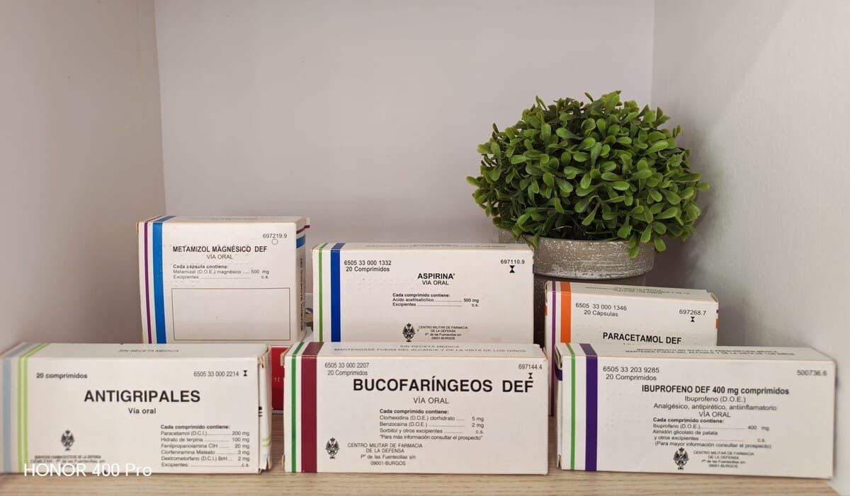 Estantes llenos de diversos frascos y cajas de medicamentos de colores en una farmacia.