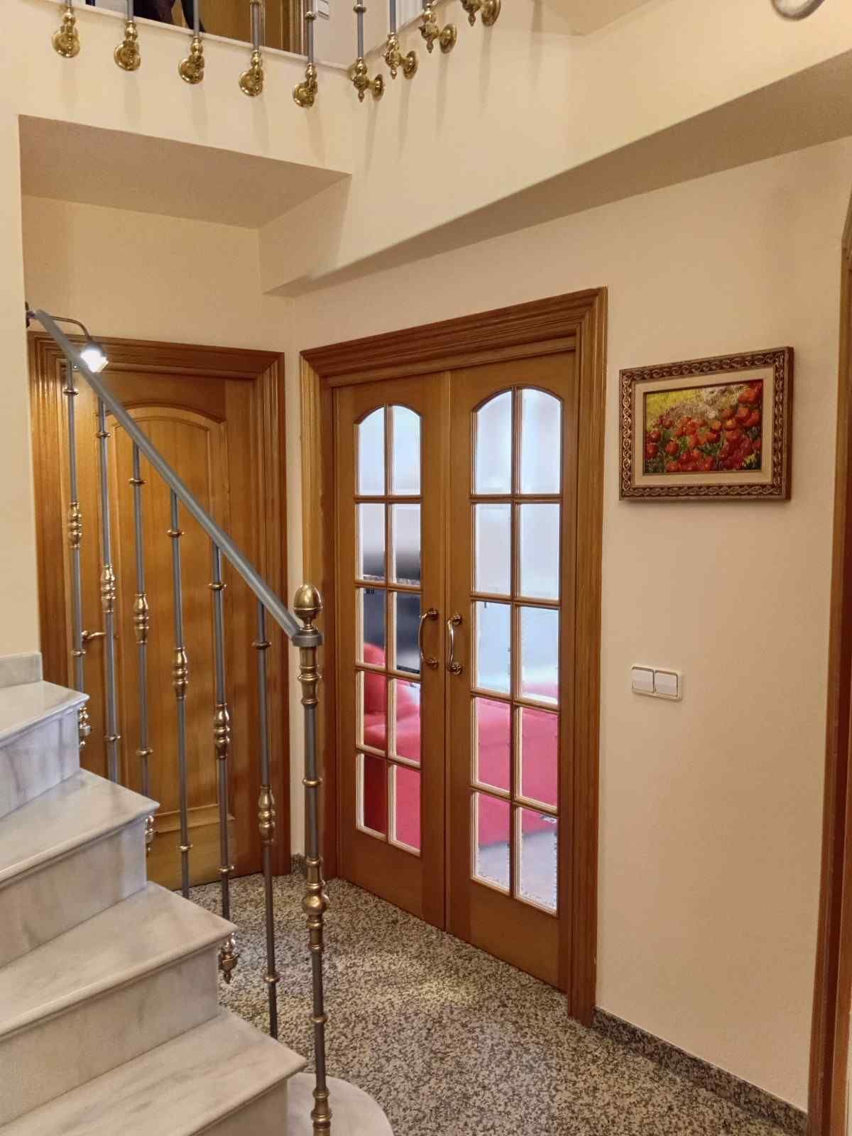 Una persona está montando un armario de madera blanca en el suelo, con los planos cerca, en una habitación luminosa.