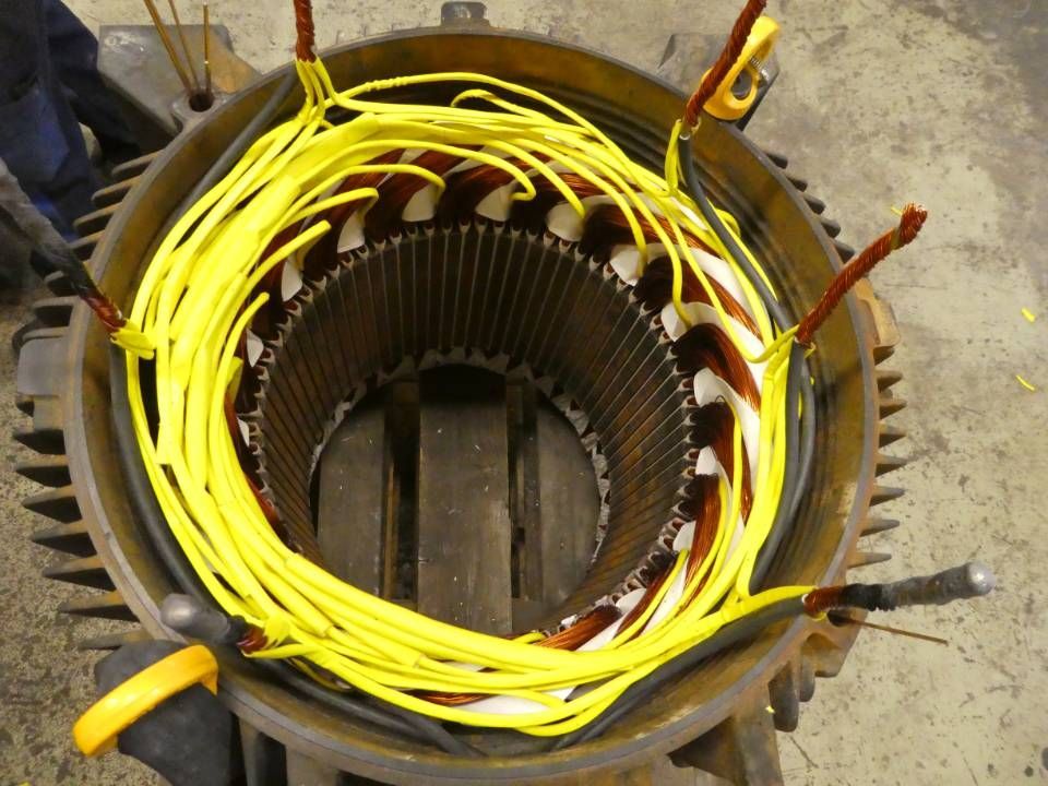 Offener Motorstator mit gelben Drähten, die um den oberen Rand gewickelt sind