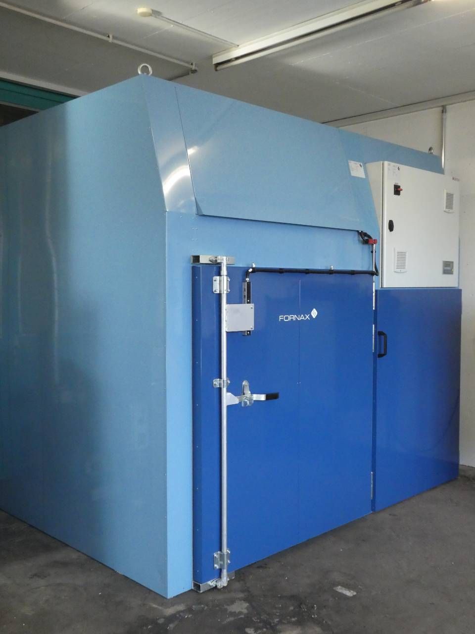 Grosser blauer Industrie-Gefrierschrank mit Metalltür in einem Lagerhaus.