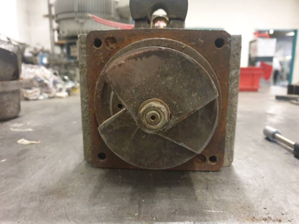 Rostiges mechanisches Metallteil mit runder Frontplatte auf einer Werkbank in einer Werkstattumgebung