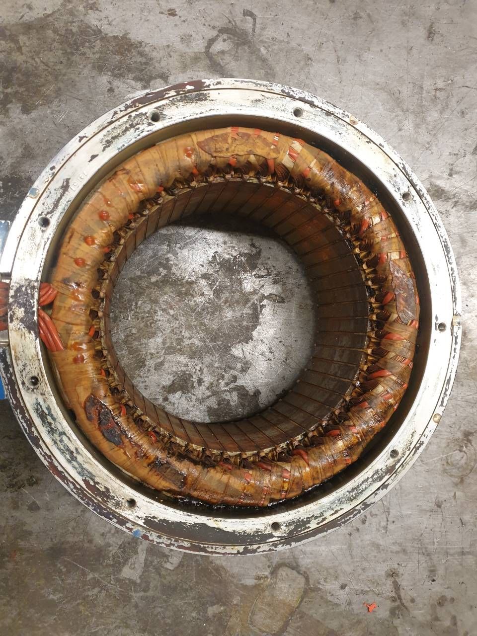 Rostiger runder Metallablauf mit korrodiertem Innenring und grauem Zentrum.
