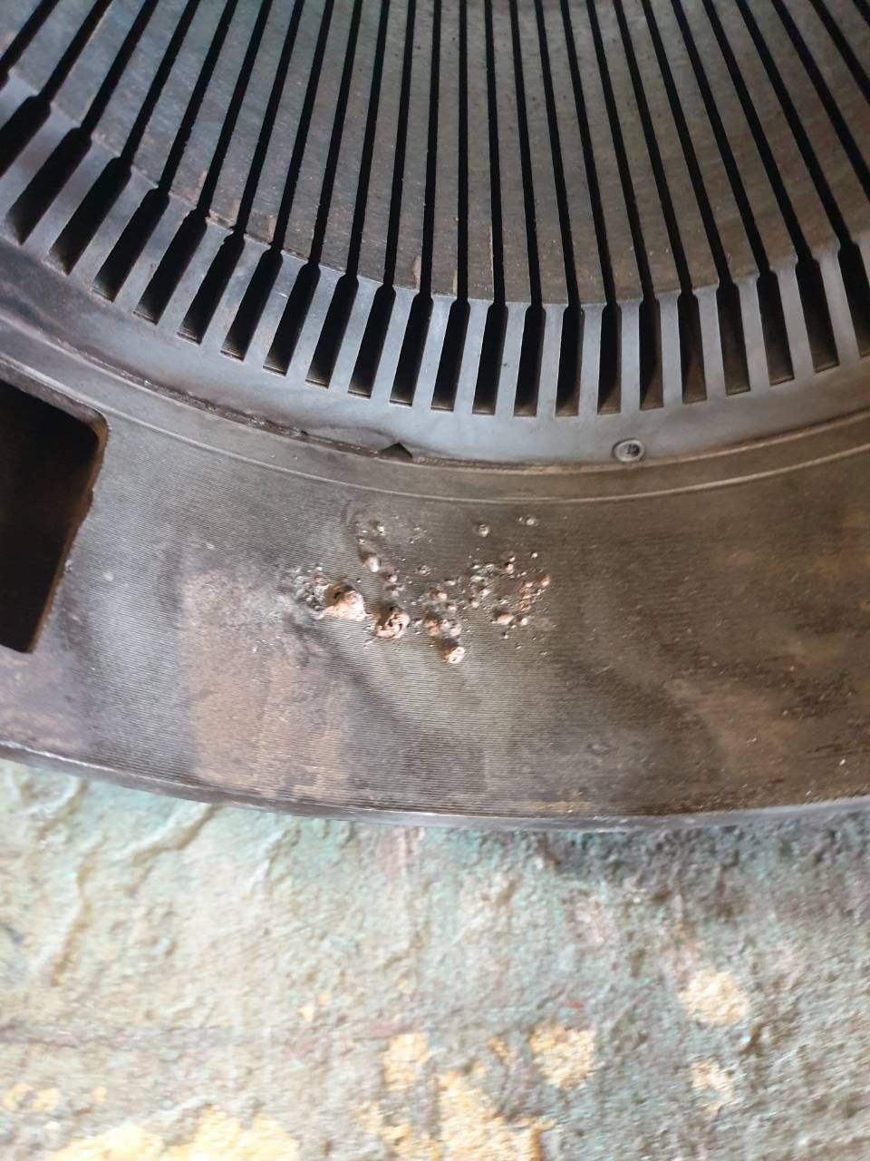 Nahaufnahme eines Metalllüftungsgitters mit einer kleinen Roststelle an der Unterkante