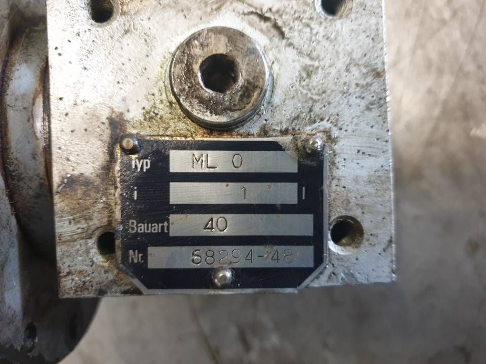 Nahaufnahme einer verschmutzten Maschinenplatte aus Metall mit eingravierten Etiketten und Nummern.