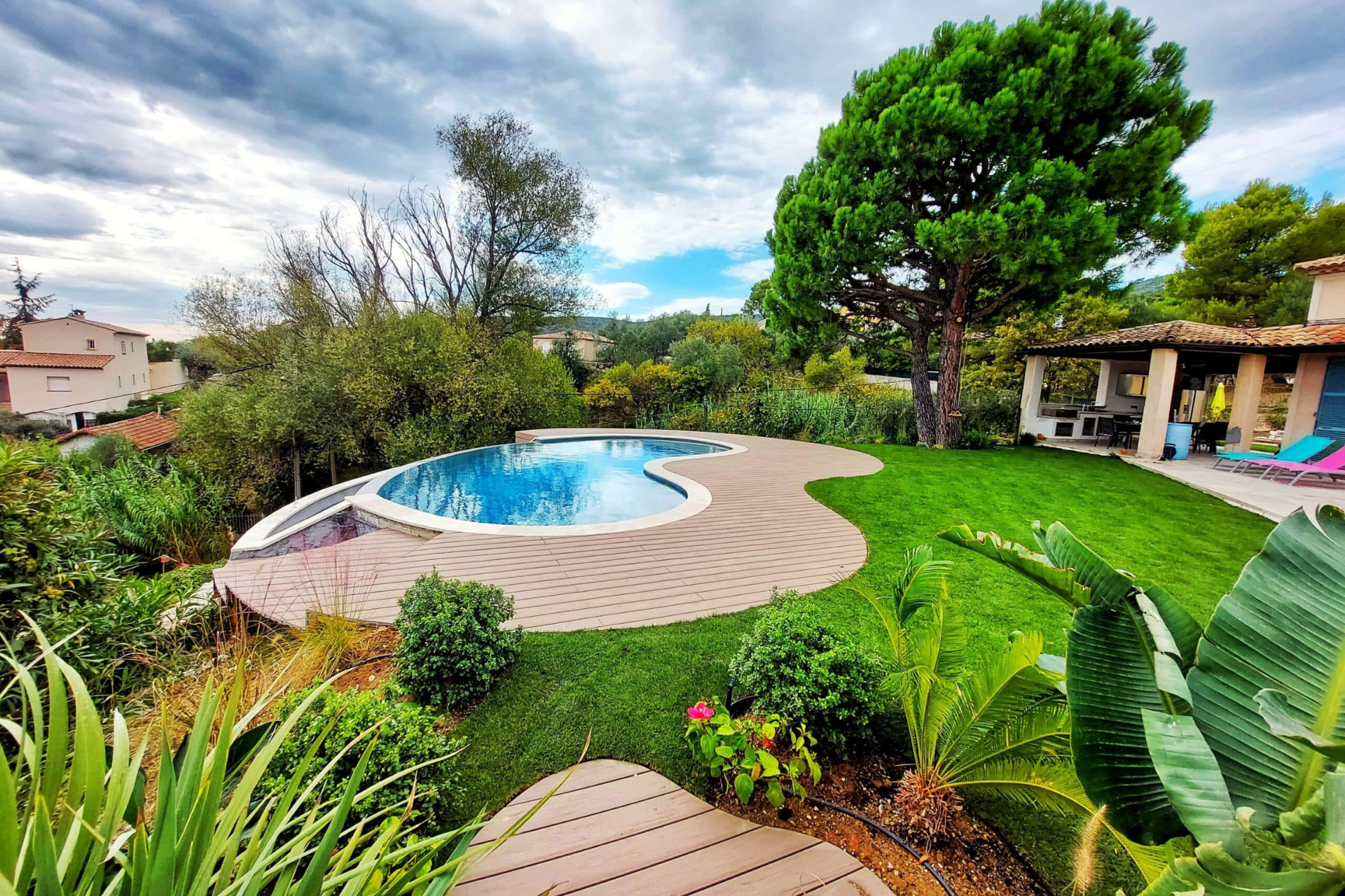 Une grande piscine se trouve au milieu d'un jardin verdoyant.