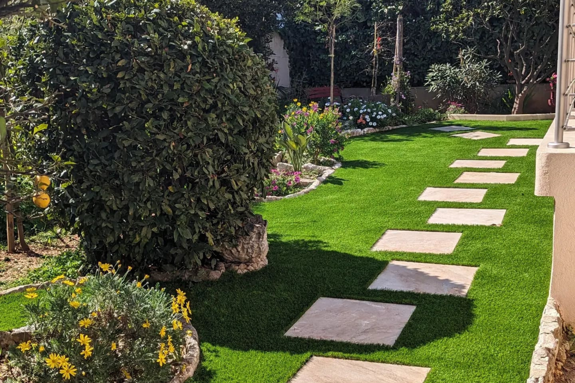 Un jardin avec une pelouse verte luxuriante et des tremplins.