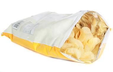 Una bolsa de patatas fritas se derrama sobre un fondo blanco.
