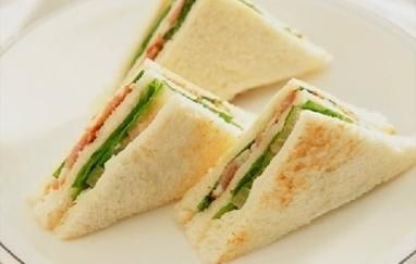 Tres sándwiches están en un plato blanco.