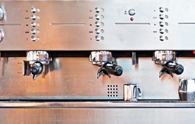 Una máquina de café de acero inoxidable está sobre un mostrador.