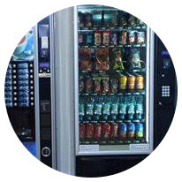 Una máquina expendedora llena de refrescos y bocadillos en un círculo.