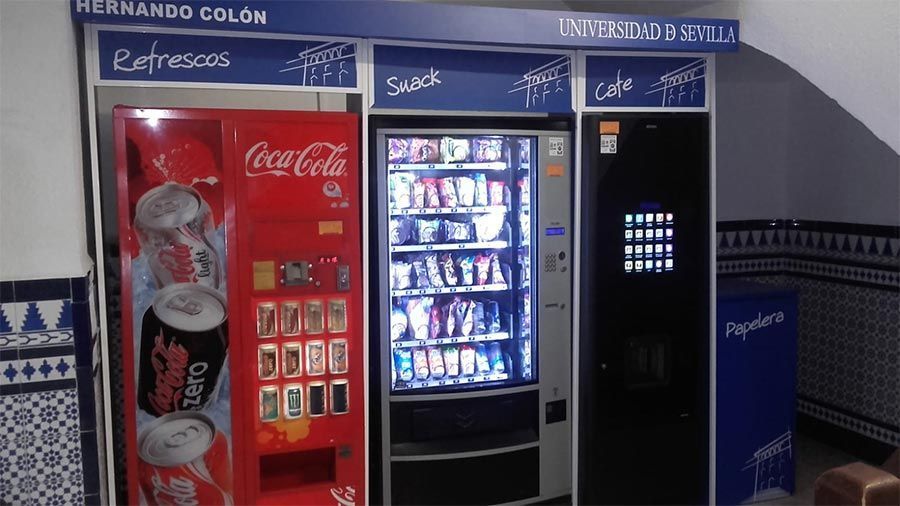 Una fila de máquinas expendedoras, incluida una máquina de Coca Cola.