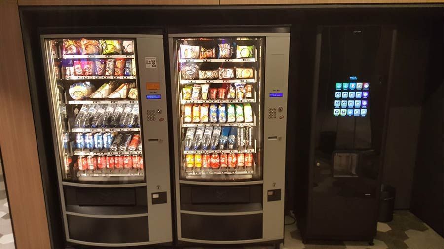 Hay dos máquinas expendedoras una al lado de la otra en una habitación.