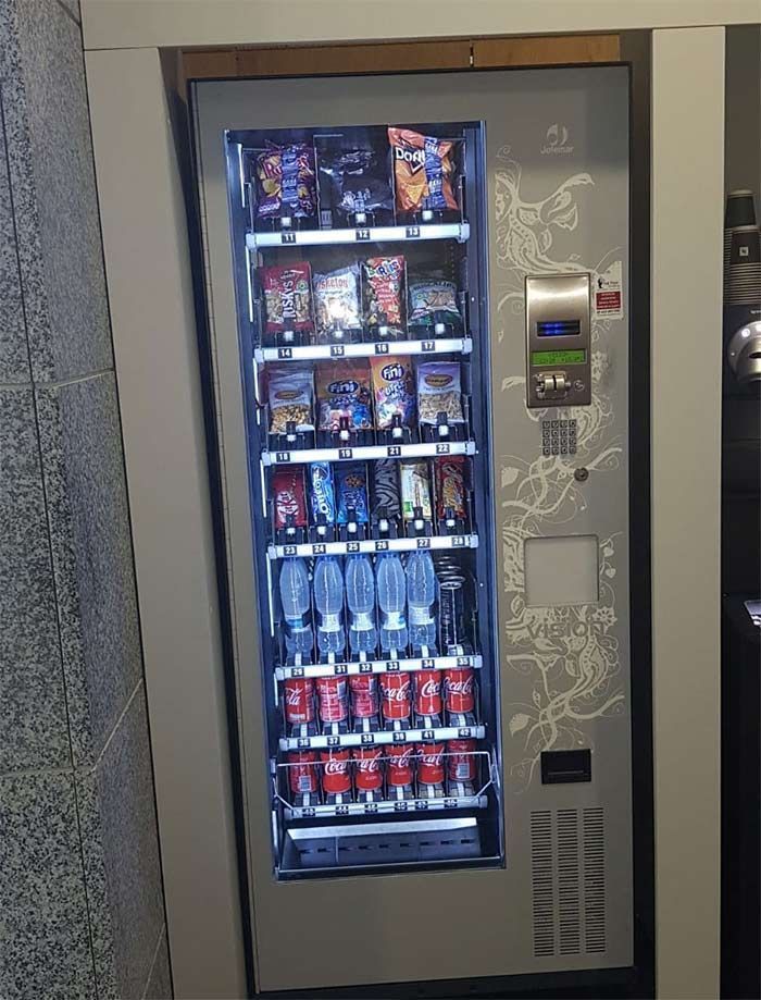 Una máquina expendedora llena de refrescos y bocadillos