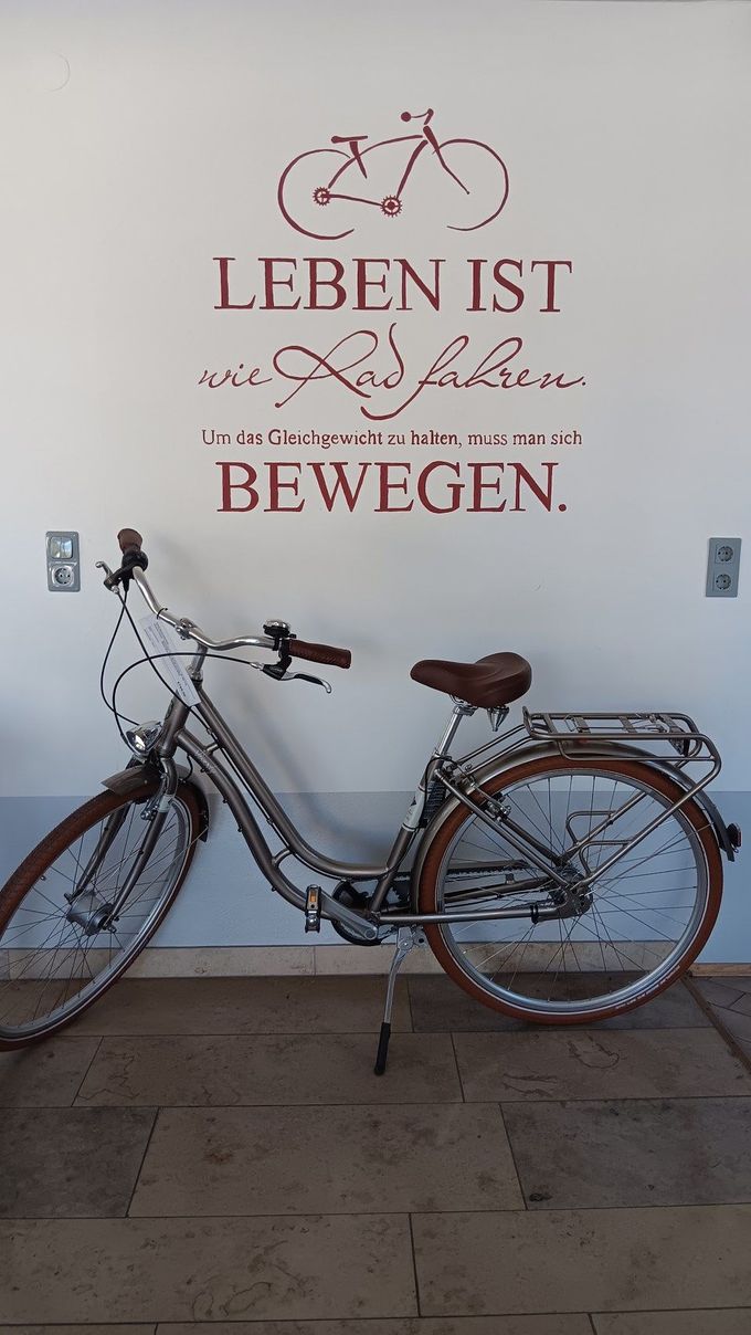 Vintage bicycle against wall with German quote “Leben ist zu kurz um sich nicht zu bewegen.”