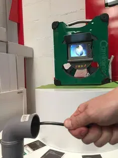 Una persona sostiene una manguera frente a una cámara.