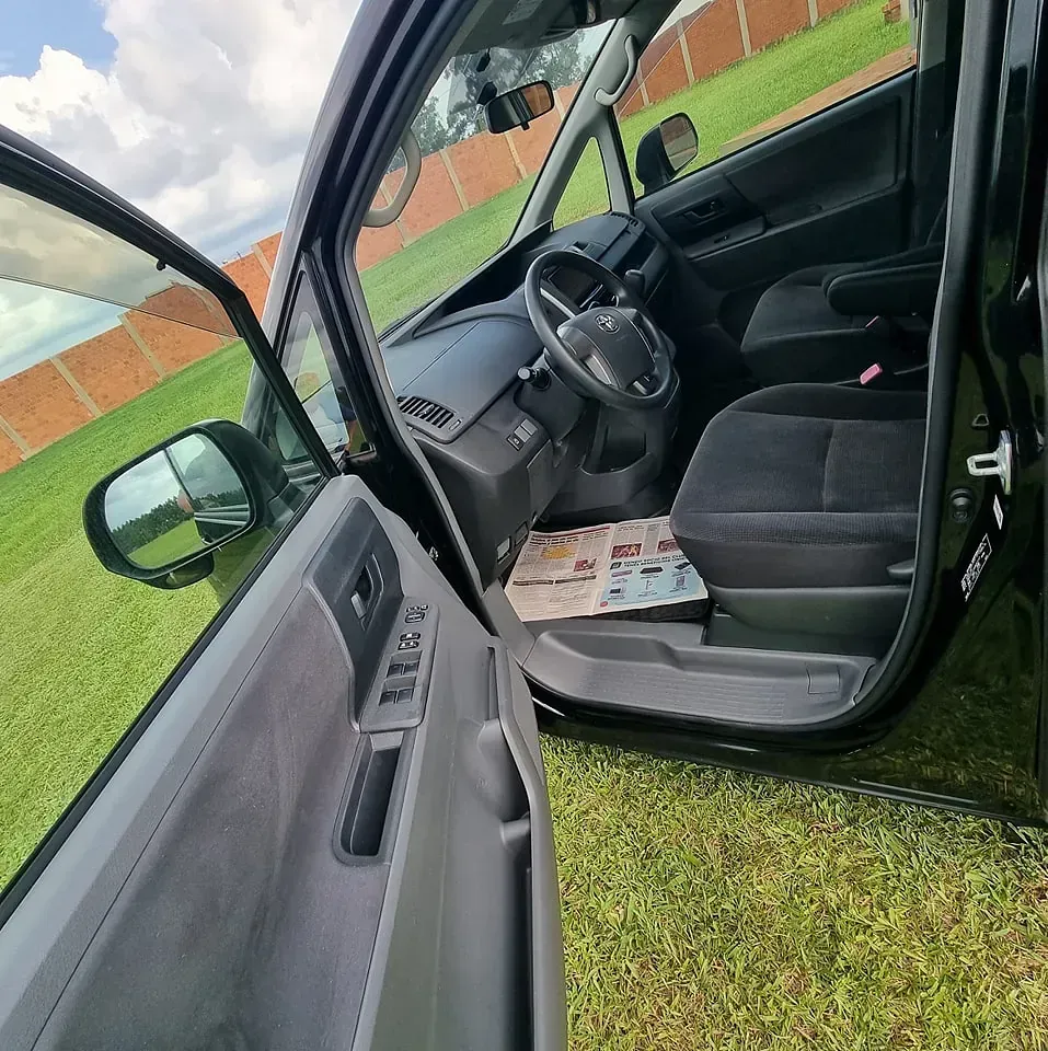 El interior de un coche negro con la puerta abierta.