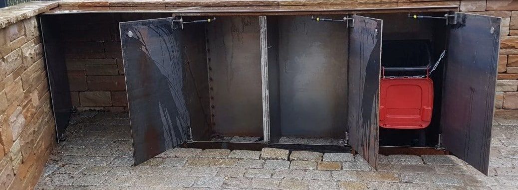 Eine Reihe dunkler Spinde, rechts davon ist eine leuchtend rote Spindtür offen.