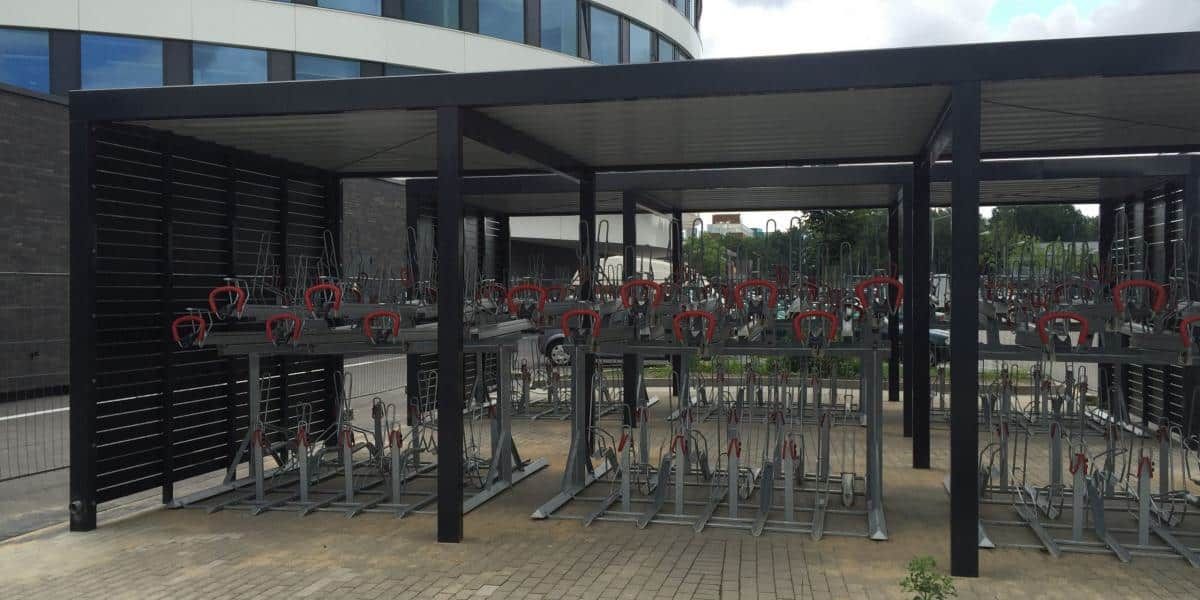 Terrasse eines Restaurants im Freien mit Tischen, Stühlen und roten Blumenkästen unter einem überdachten Vordach