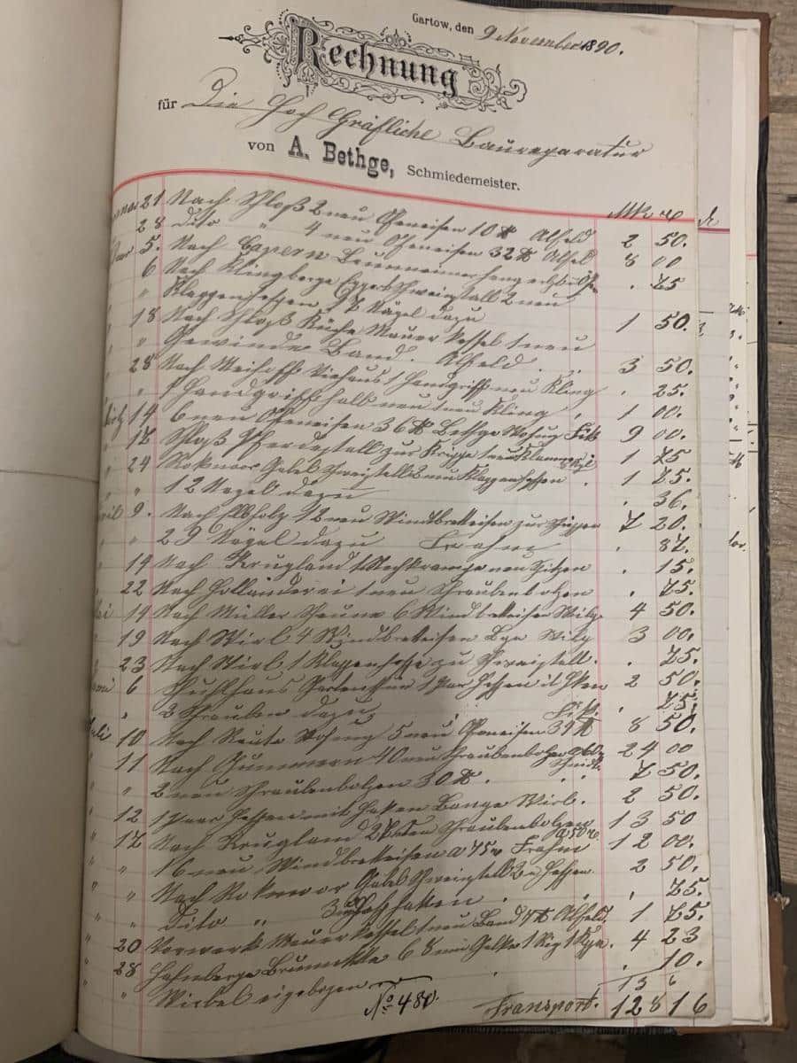 Handgeschriebene Kontobuchseite mit Spalten von Einträgen und Zahlen, umrahmt von einer roten Randlinie auf gealtertem Papier