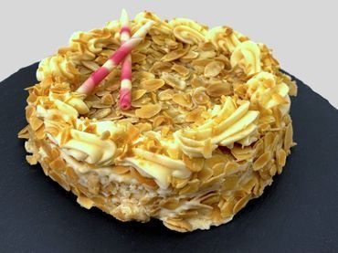 Un pastel con una vela encima está sobre un plato negro.