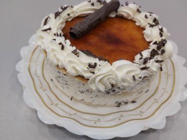 Un pastel con crema batida y chispas de chocolate en un plato blanco
