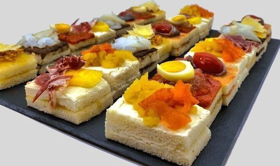 Una bandeja de sándwiches con diferentes ingredientes sobre una mesa.