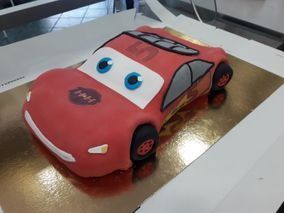 Un pastel con la forma de un coche de Rayo McQueen