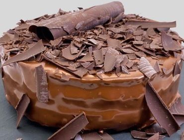 Un pastel de chocolate con virutas de chocolate encima.