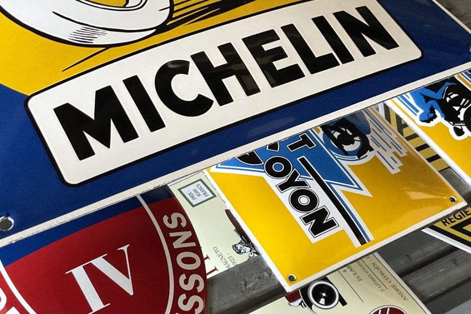 Michelin, Yokohama et d'autres marques de pneus vintage sont superposées, affichant des couleurs vives.