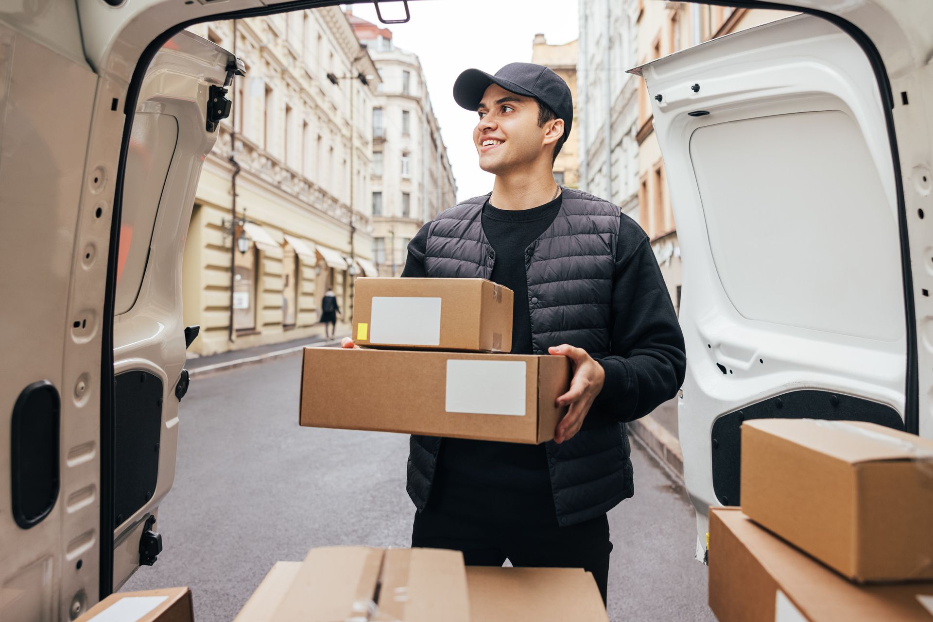 Un repartidor lleva cajas desde la parte trasera de una camioneta.