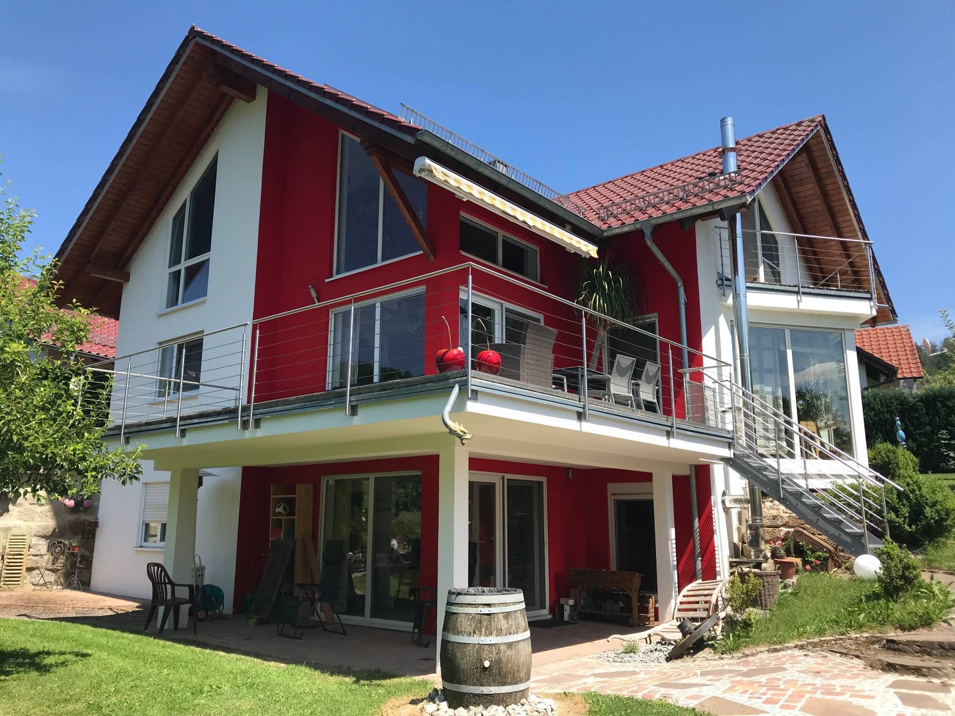 Ein großes rot-weißes Haus mit Balkon und Treppe