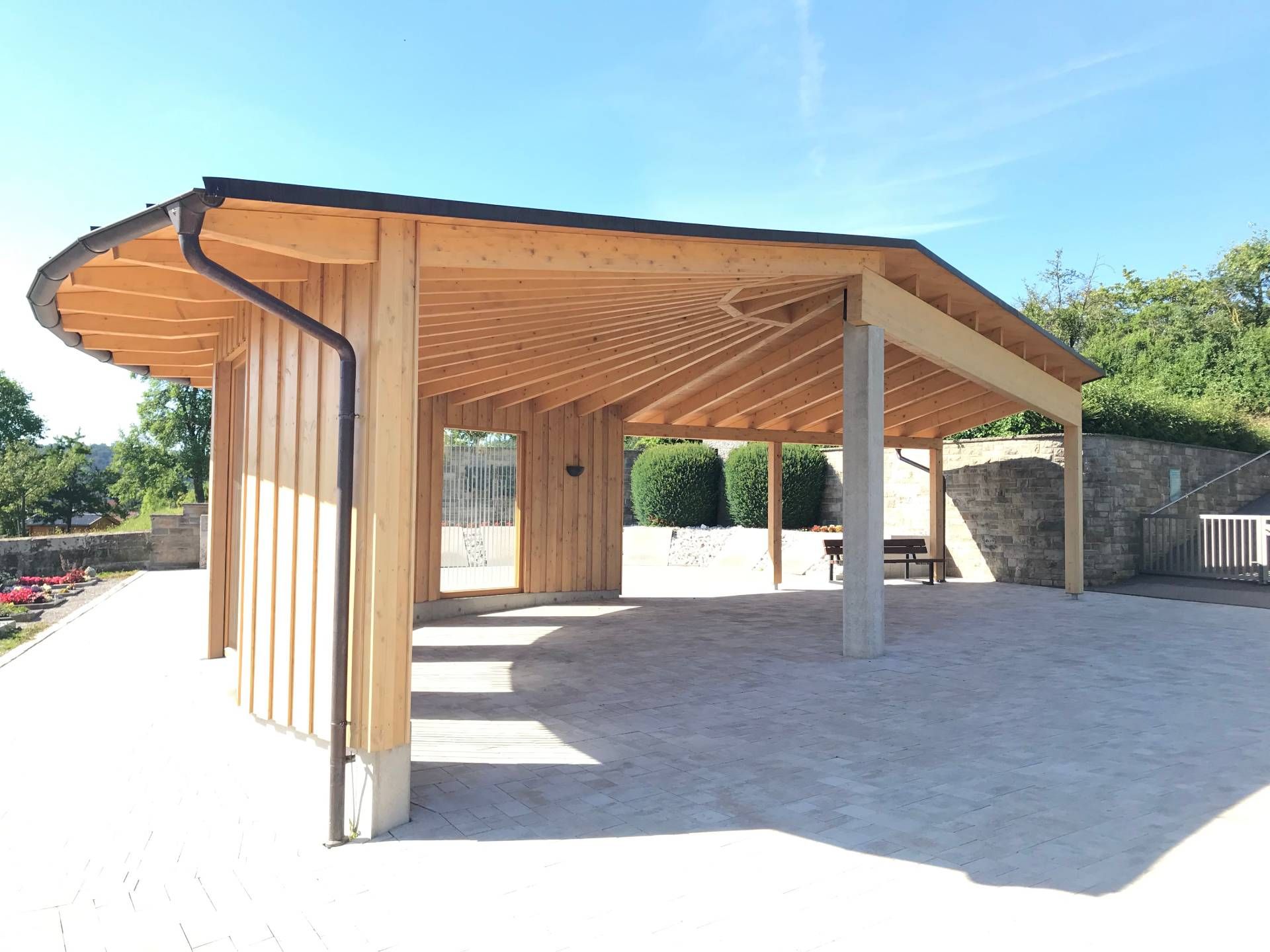 Eine Holzkonstruktion mit einem Dach und einem Fallrohr an einem sonnigen Tag