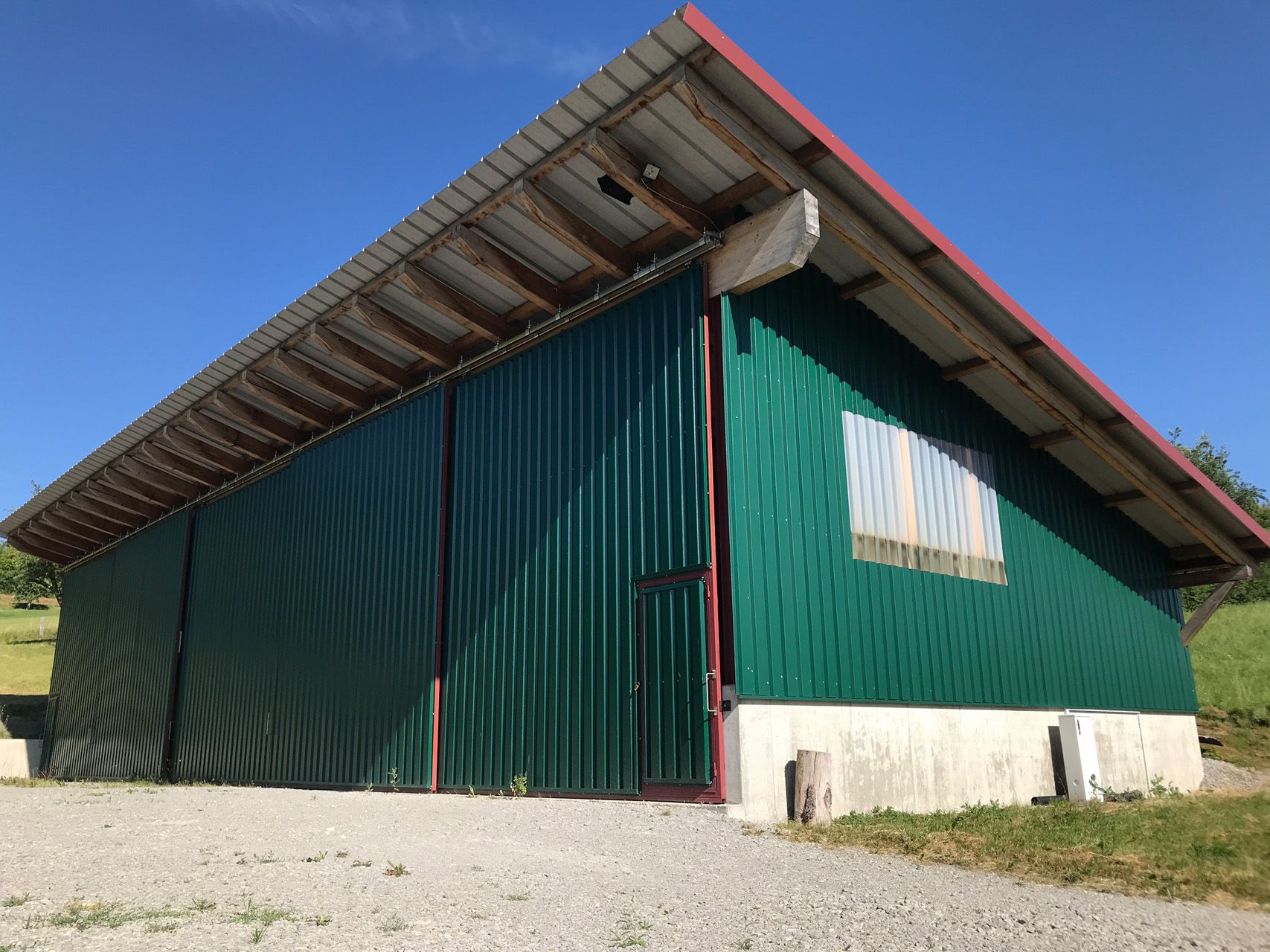 Ein großes grünes Gebäude mit einem roten Dach