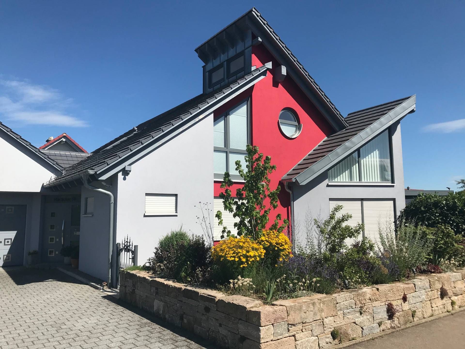 Ein rot-weißes Haus mit einem runden Fenster auf dem Dach