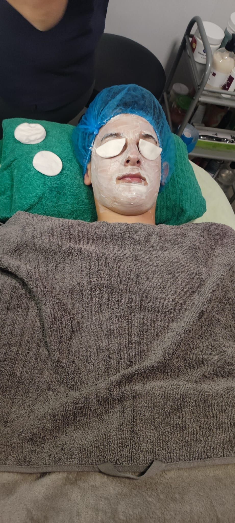 Una mujer está acostada en una cama con una máscara en la cara.